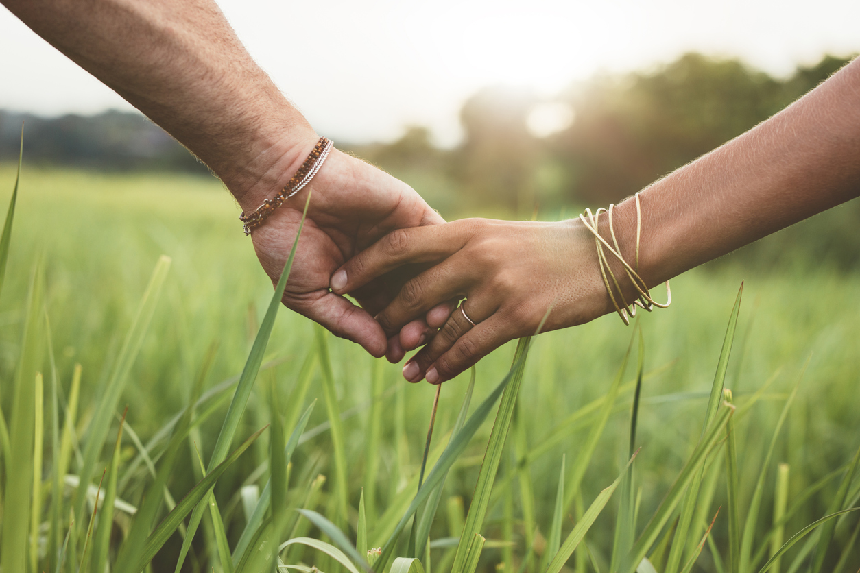 Romantic couple holding hands in a field